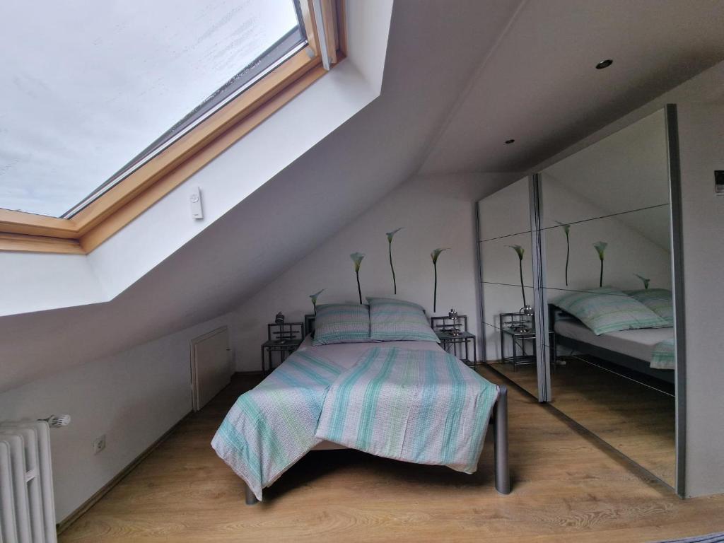 曼海姆Cheerful Roof Flat in a Private German Style House的一间卧室设有一张床和一个大窗户