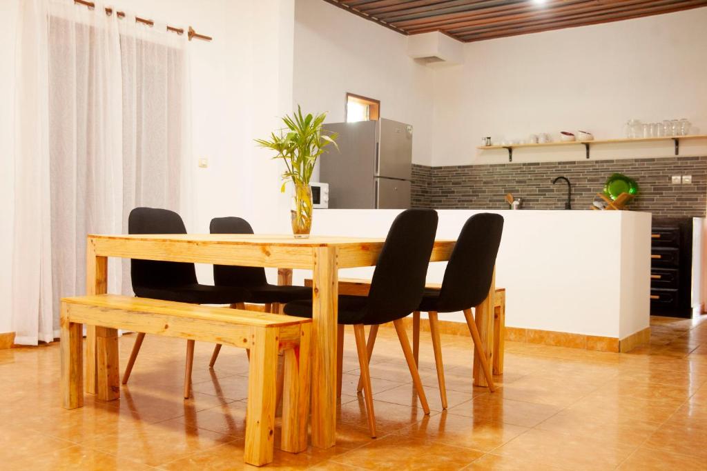 AntsakomboenaVILLA TIARÉ DIEGO的一张带黑色椅子的木桌和厨房