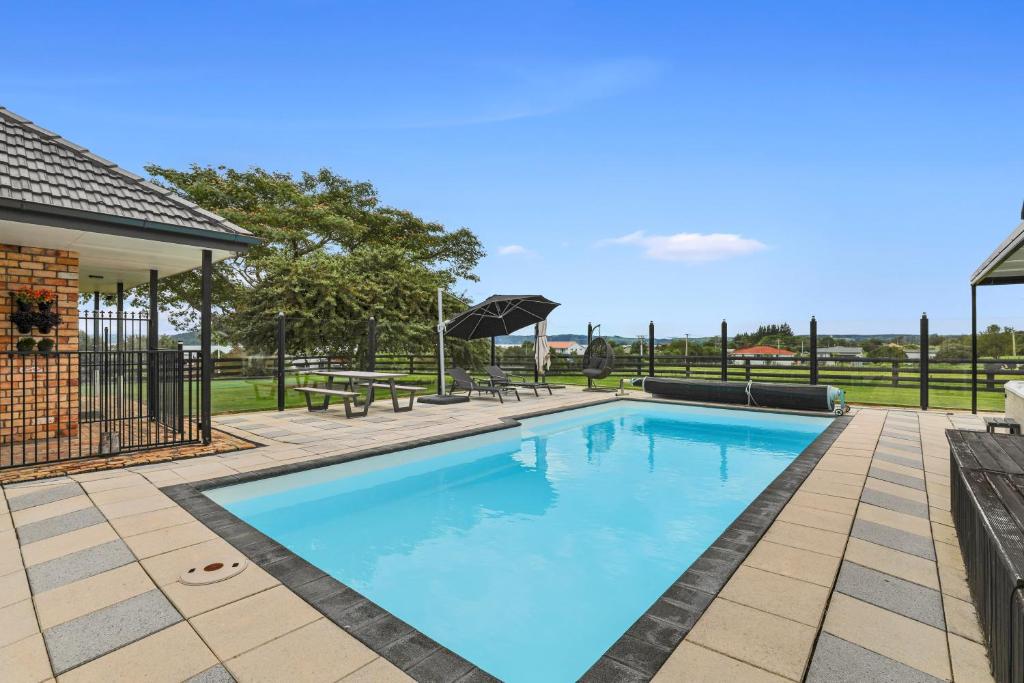 罗托鲁瓦Airport Oasis的庭院里的一个蓝色海水游泳池