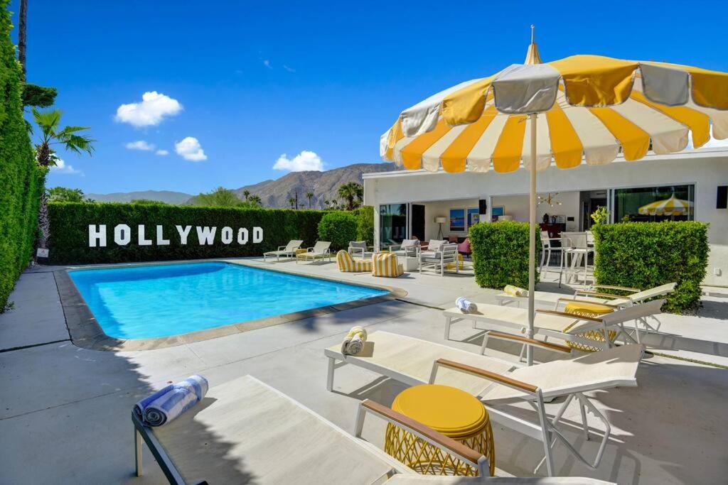 棕榈泉Palm Springs Luxury Home With a POOL, Next to Downtown & Airport的一个带椅子和遮阳伞的游泳池