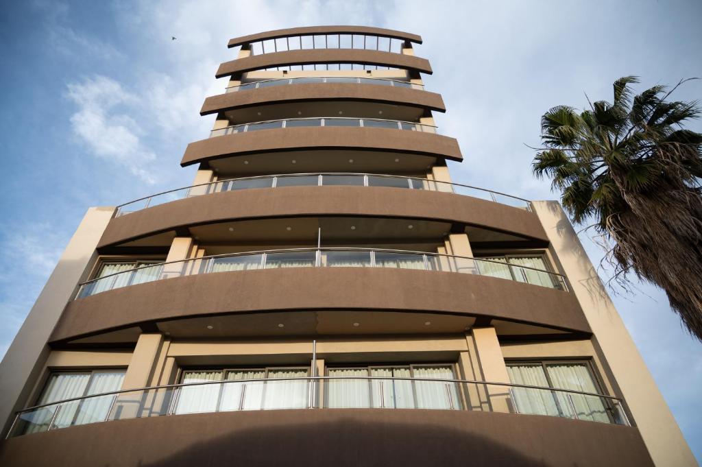 迈普Apartamento Pescara 60的一座高大的建筑,有一座棕榈树环绕的圆塔