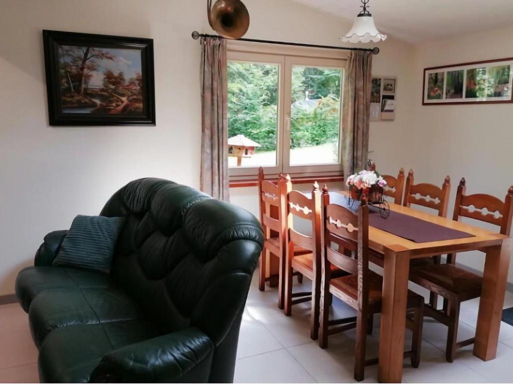 威布林Authentic chalet in Wibrin with private fish pond的客厅配有桌子和真皮沙发