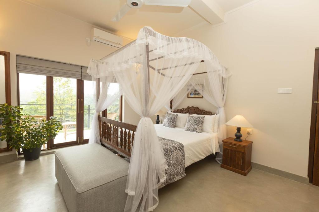 康提Edgar Mansion Kandy的一间卧室配有天蓬床和沙发