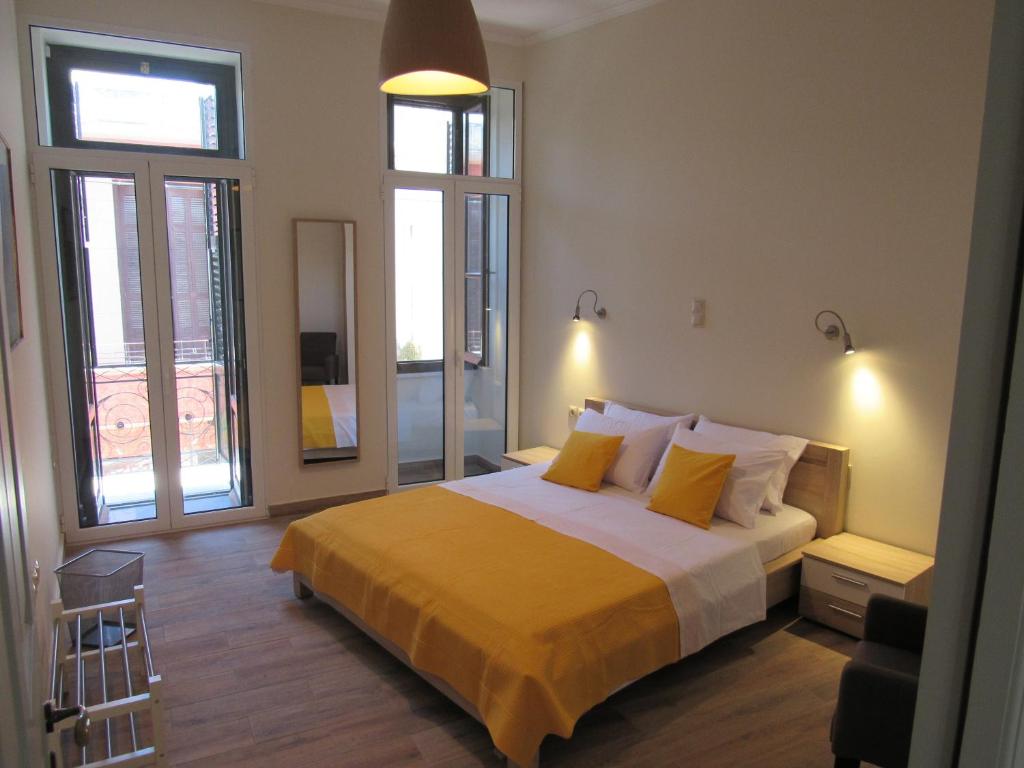 雅典克拉美恩公寓的一间卧室配有一张带黄色床单和窗户的床。