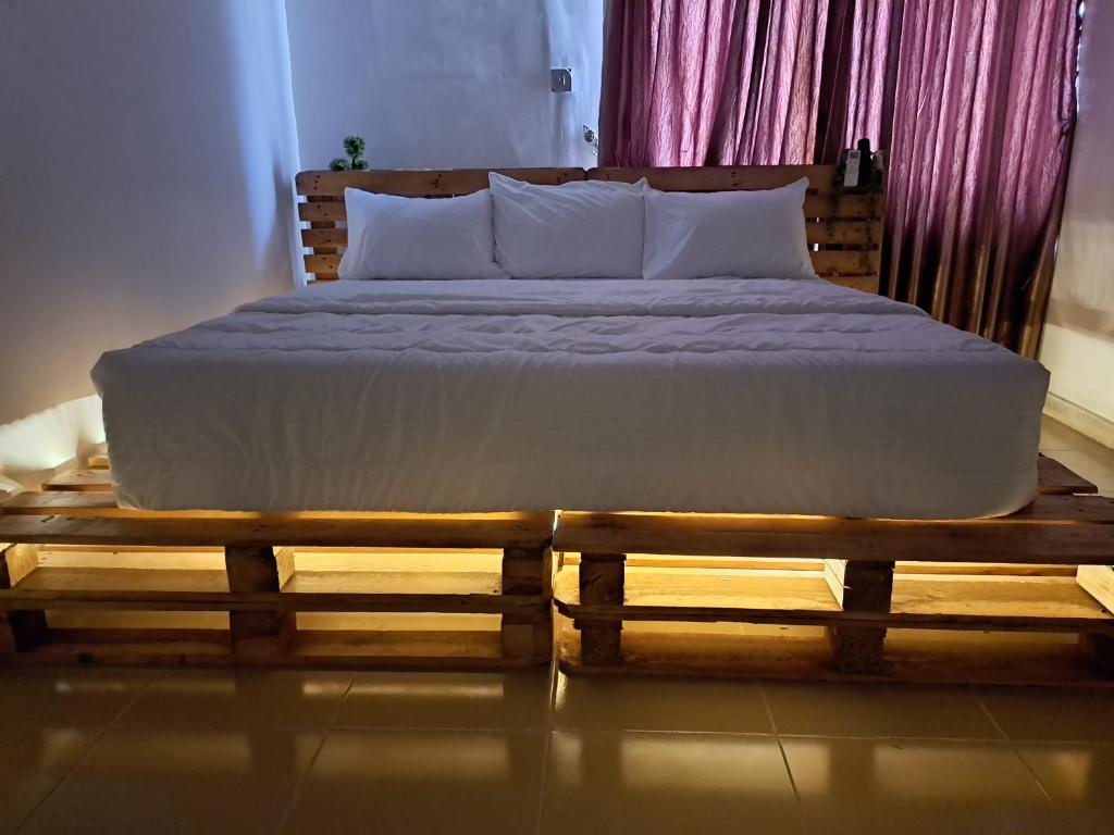 伊巴丹Igbalode Luxury Apartment的卧室里一张木平台上的床铺