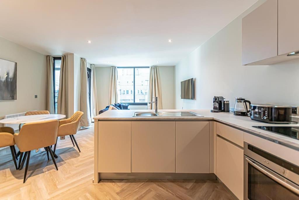 利物浦Luxurious 1 Bed - CITY VIEW的厨房配有水槽和桌椅