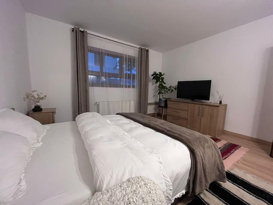 TÄƒuÅ£ii MÄƒgheruÅŸRustic house的卧室设有一张白色大床和一扇窗户。