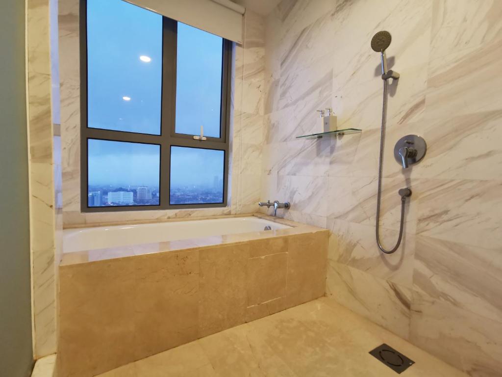 马六甲Attic Home Melaka Silverscape Residence & Jonker的带浴缸的浴室和窗户。