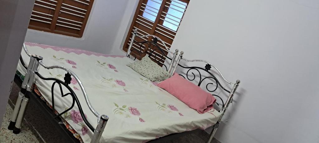 蓬蒂切里Major Madi Residency的一张金属床,上面有粉红色枕头