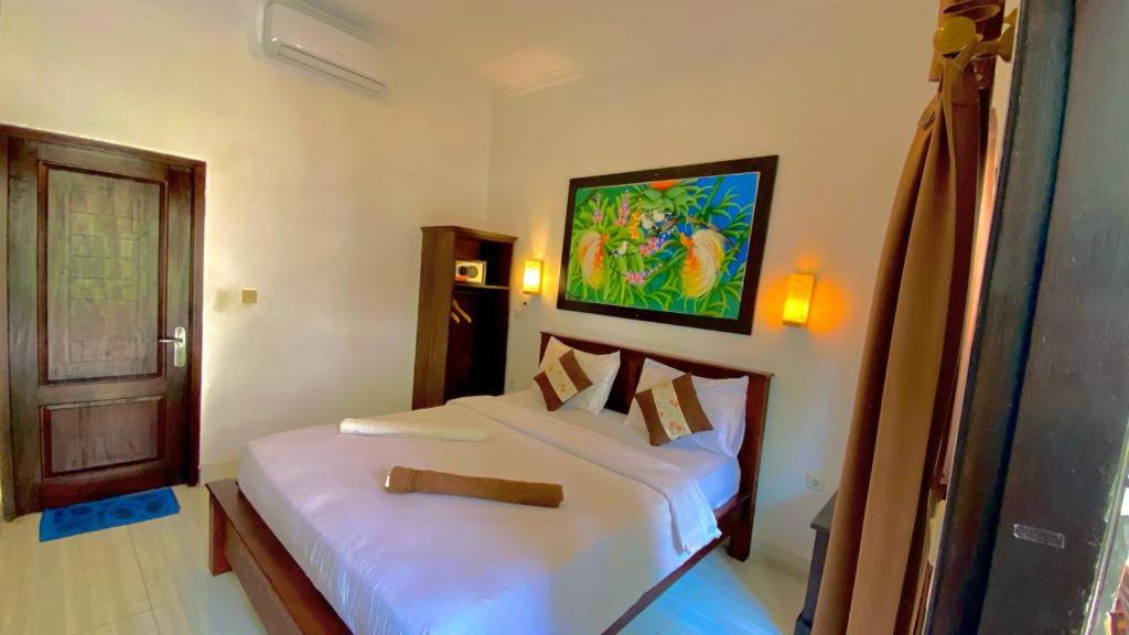 吉利特拉旺安帕丹塔宾馆的卧室配有2张白色的床和墙上的绘画作品