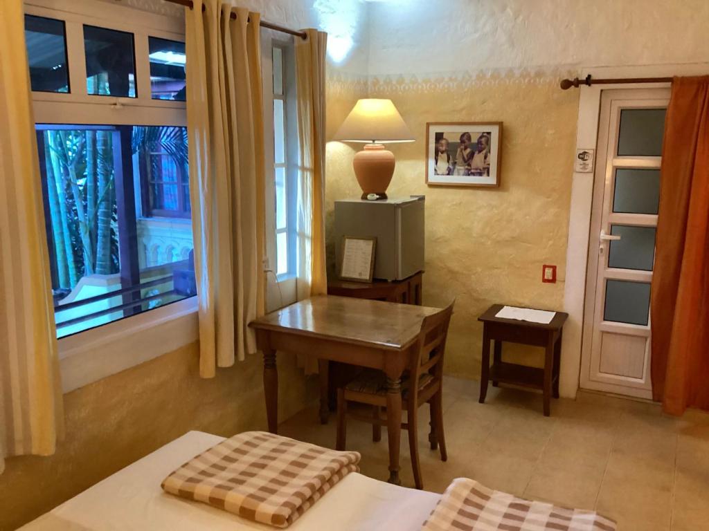 拉戈莱特拉莱因克里奥尔酒店的一间卧室配有书桌、桌子和窗户。