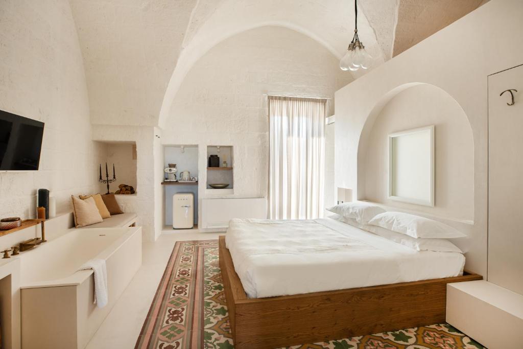 法萨诺AL PALAZZO La Dimora by Apulia Hospitality的白色的卧室设有一张大床和一间浴室。