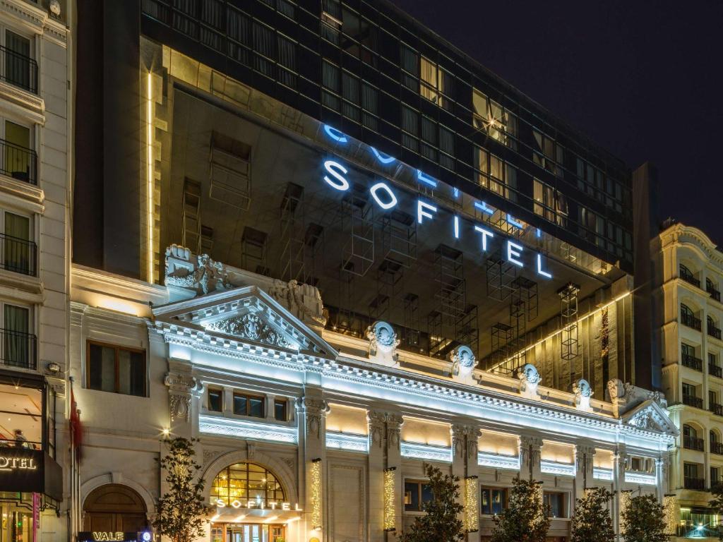 伊斯坦布尔Sofitel Istanbul Taksim的一座建筑物,上面有夜间标志