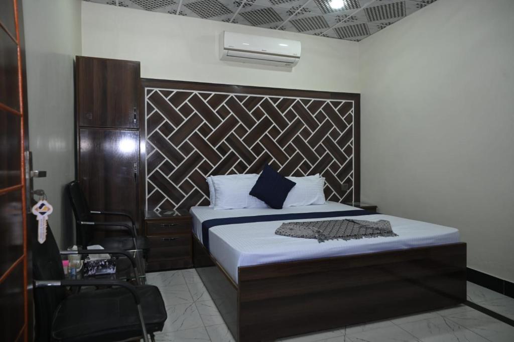 卡拉尔哥特Hotel Serina Inn的一间卧室配有一张带木制床头板的床