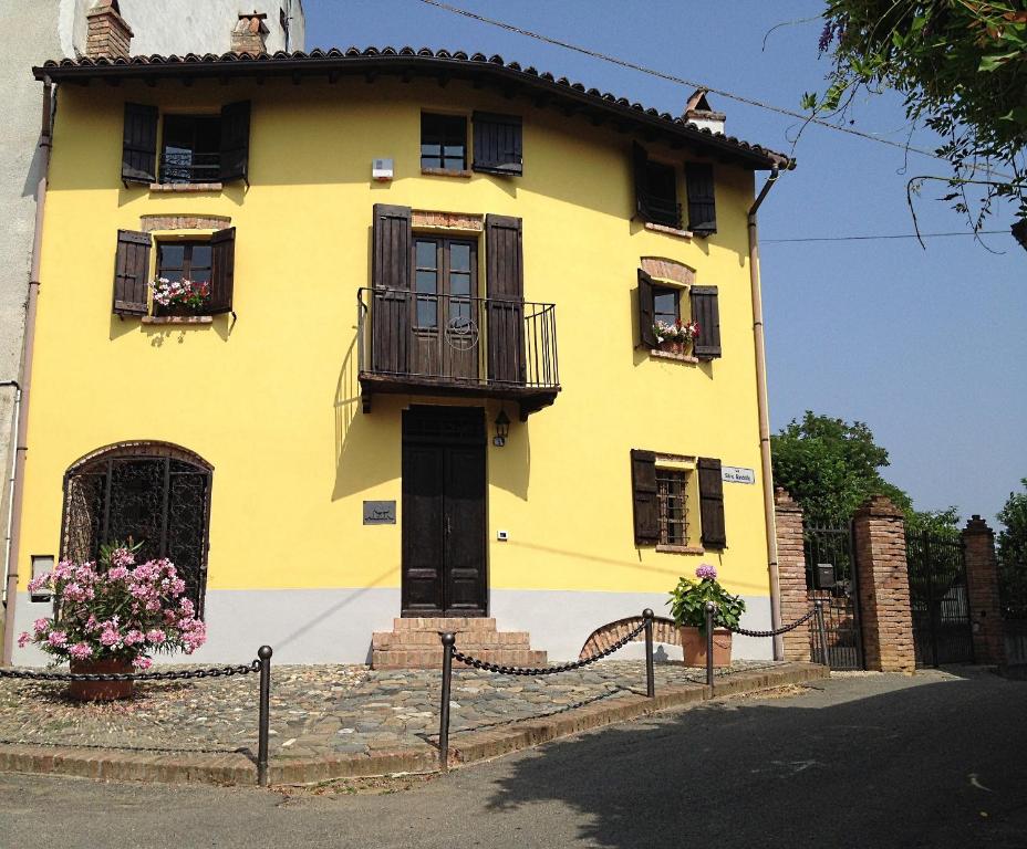 蒙巴鲁佐Altes Backhaus in Maranzana的黄色的房屋设有窗户和阳台