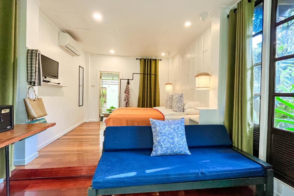 库德岛Baan Bua Cottage SHA EXTRA PLUS B5510的一间卧室配有一张床和一张蓝色的沙发