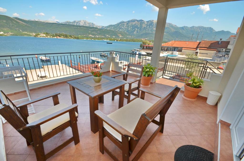 蒂瓦特Apartments Dubravcevic的阳台配有桌椅,享有水景。