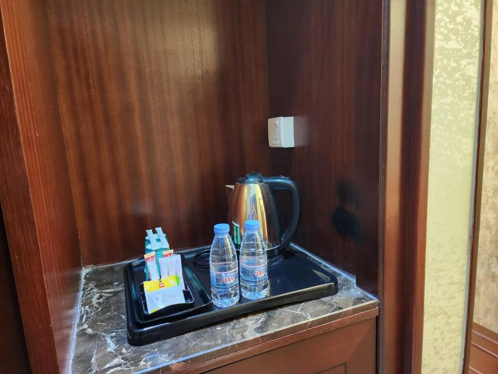 吉达EWG Al Hamra Hotel的一个带瓶装水和茶壶的托盘