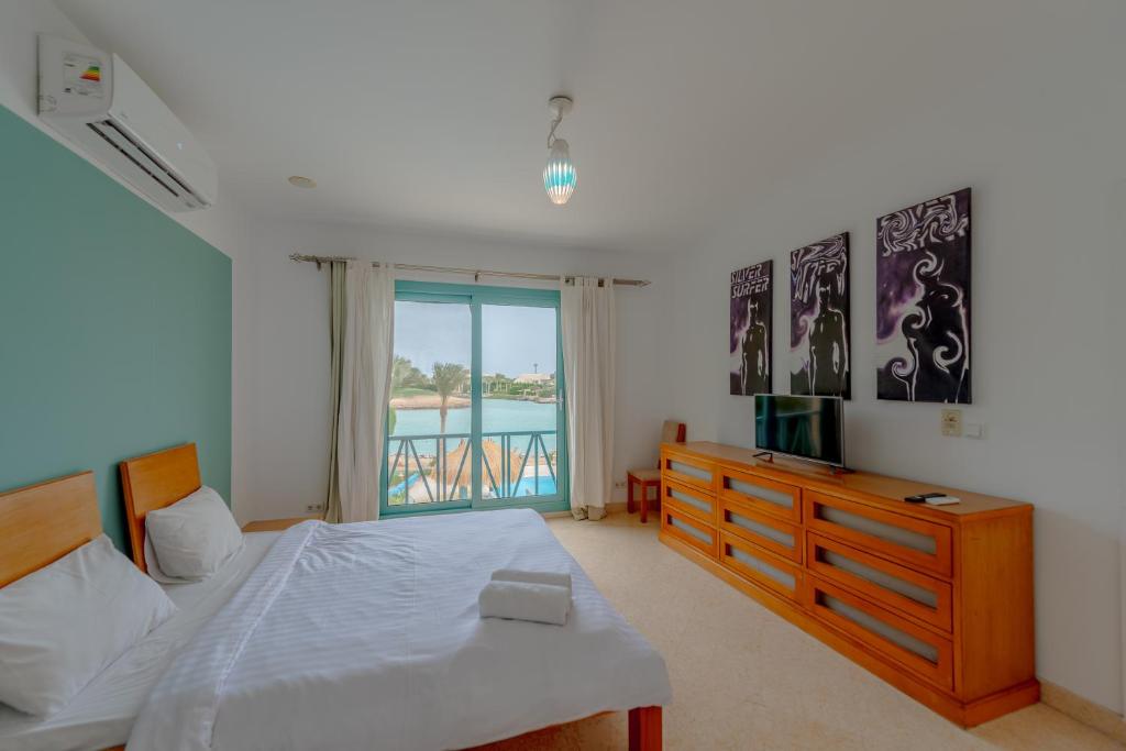 赫尔格达Stunning Villa for Rent in El Gouna HEATED PRIVATE POOL的一间卧室配有一张床、一台电视和一个窗口