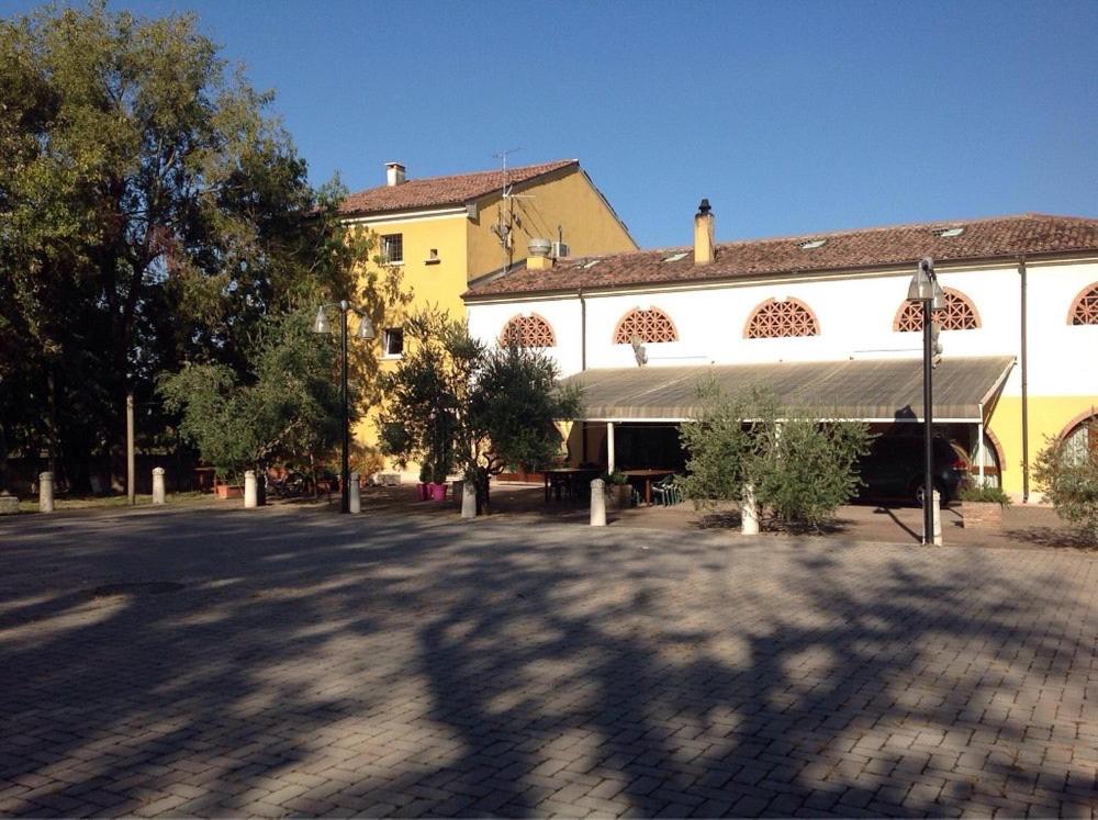 曼托瓦诺港Agriturismo La Rasdora的一条大黄楼,在街上有天篷