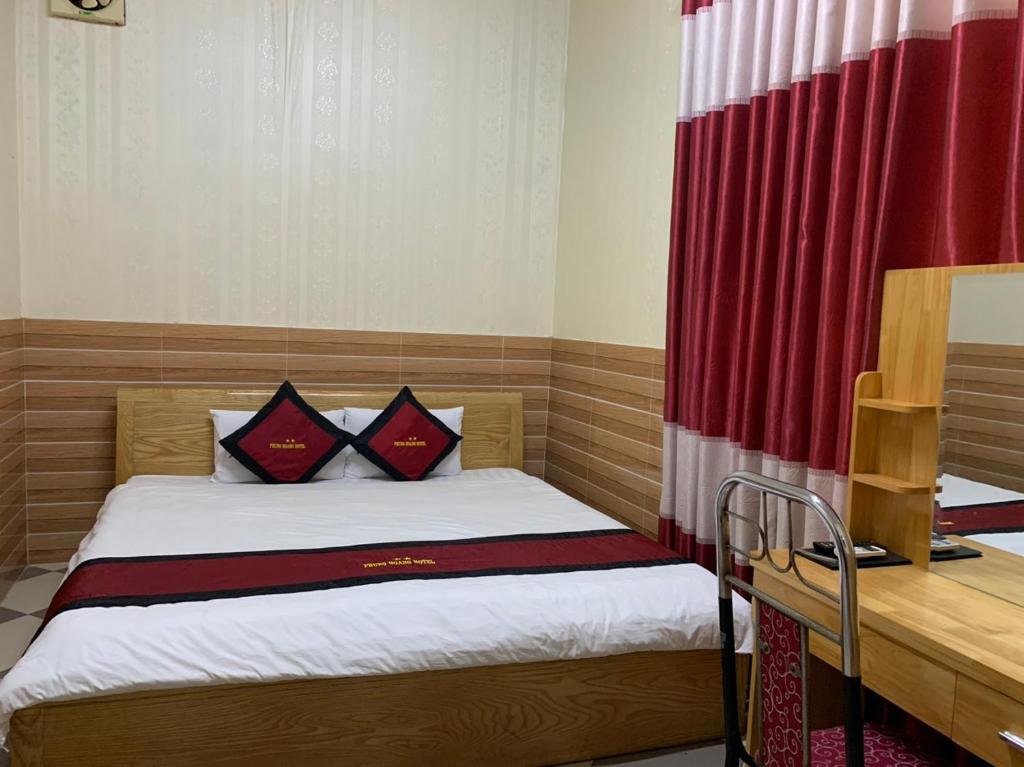Quang TriKHÁCH SẠN PHỤNG HOÀNG的一间小卧室,配有一张带红色窗帘的床