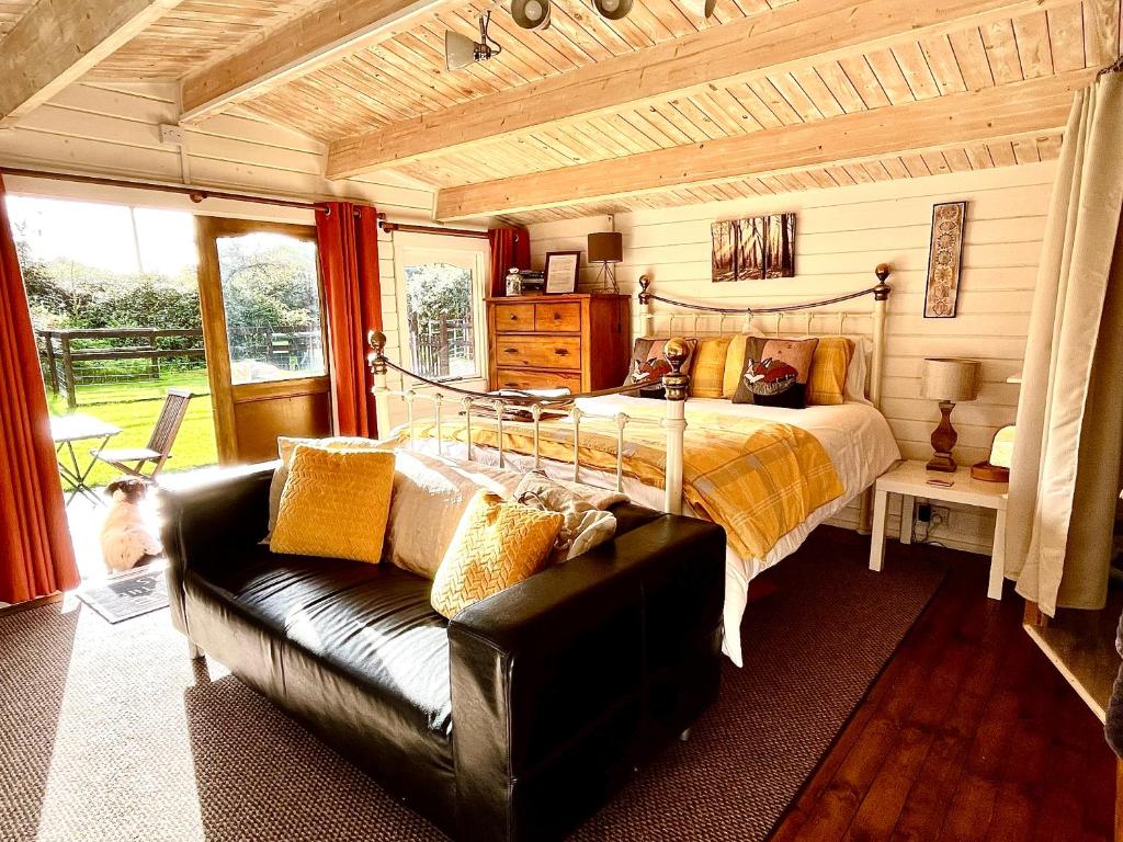 多切斯特Primrose Cabin的一间卧室配有一张床和一张沙发