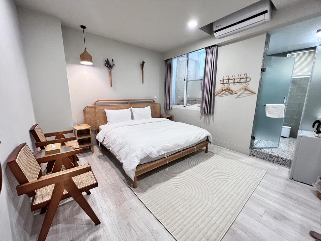 台南河趣泊旅 River Chill Inn的一间卧室配有一张床、一把椅子和一张桌子