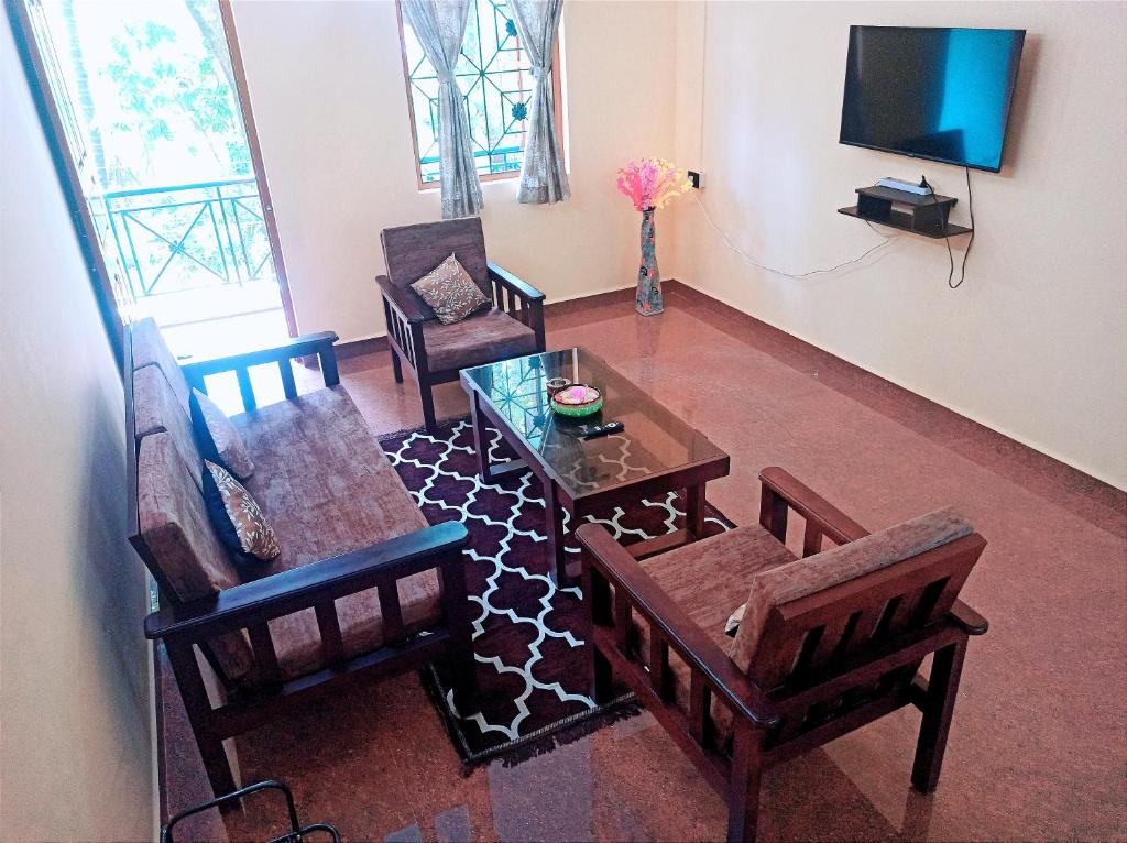 VelcaoBenirosa Homestay Apartments 2的客厅配有椅子、桌子和电视