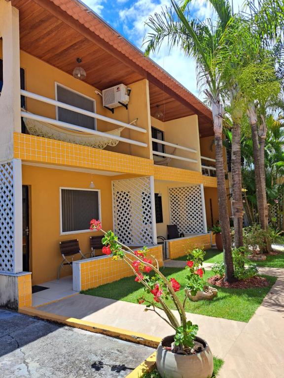 萨尔瓦多Vilage Taipan 02 - Praia Stella Maris的一座黄色房子,前面有一棵棕榈树