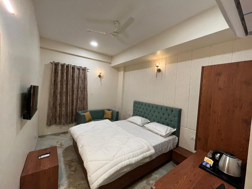 印多尔Kasa Comfort Inn的一间卧室配有一张大床和绿色床头板