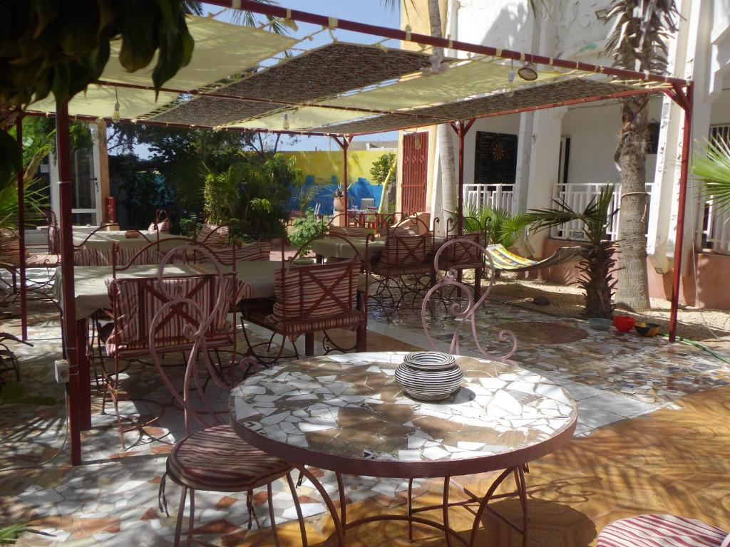 努瓦克肖特Auberge Triskell的庭院配有桌椅和遮阳伞。