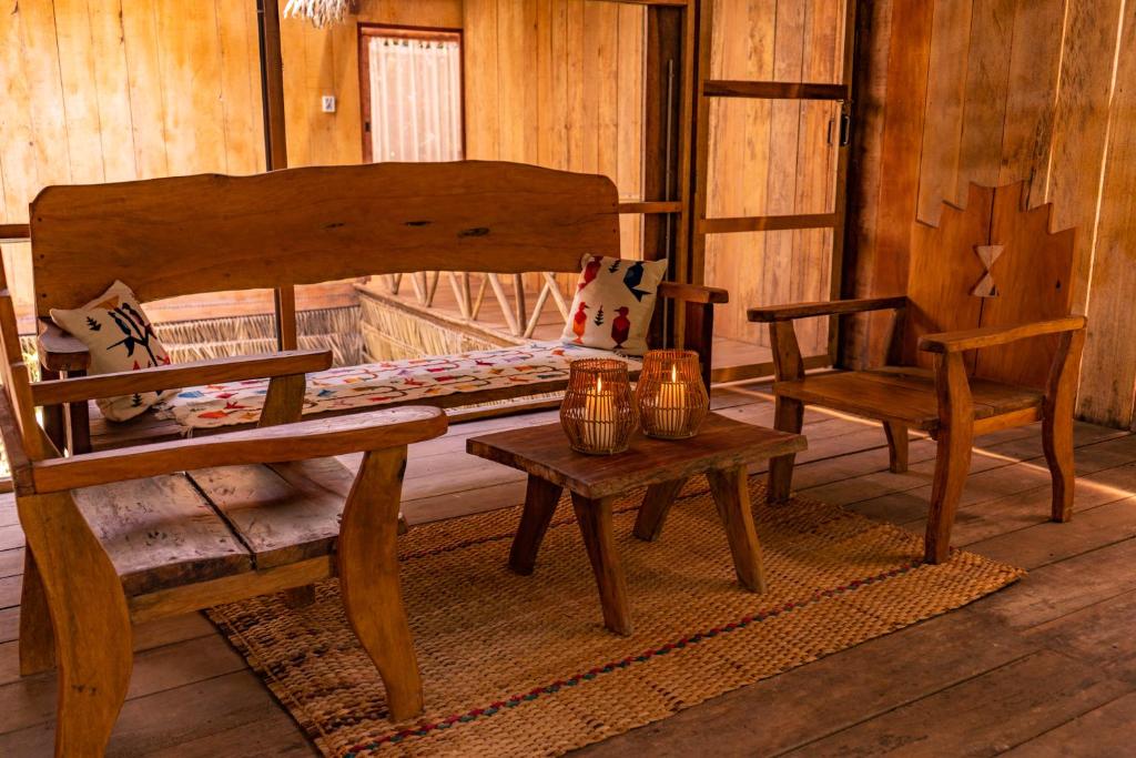 伊基托斯Family hotel PURMA CASPI on the jungle lake的客房设有床、长凳和桌子。