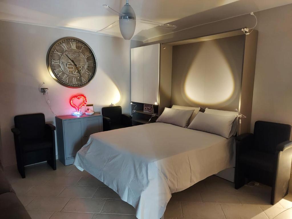 菲亚诺Dimora Rosso 27的卧室配有一张床,墙上挂着一个钟