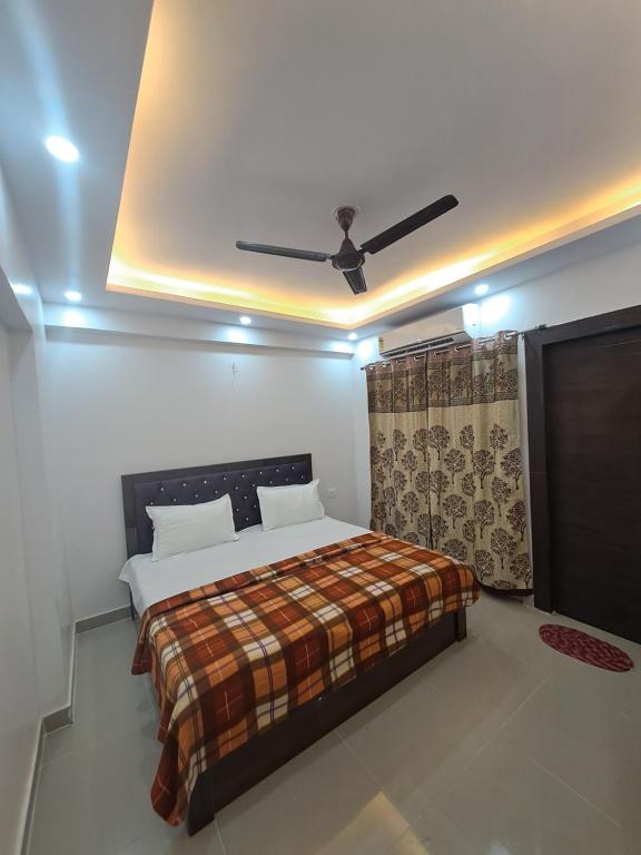 加济阿巴德Gokul 3BHK Service Apartment Bharat City Ghaziabad near Hindon Airport的一间卧室配有一张床和吊扇