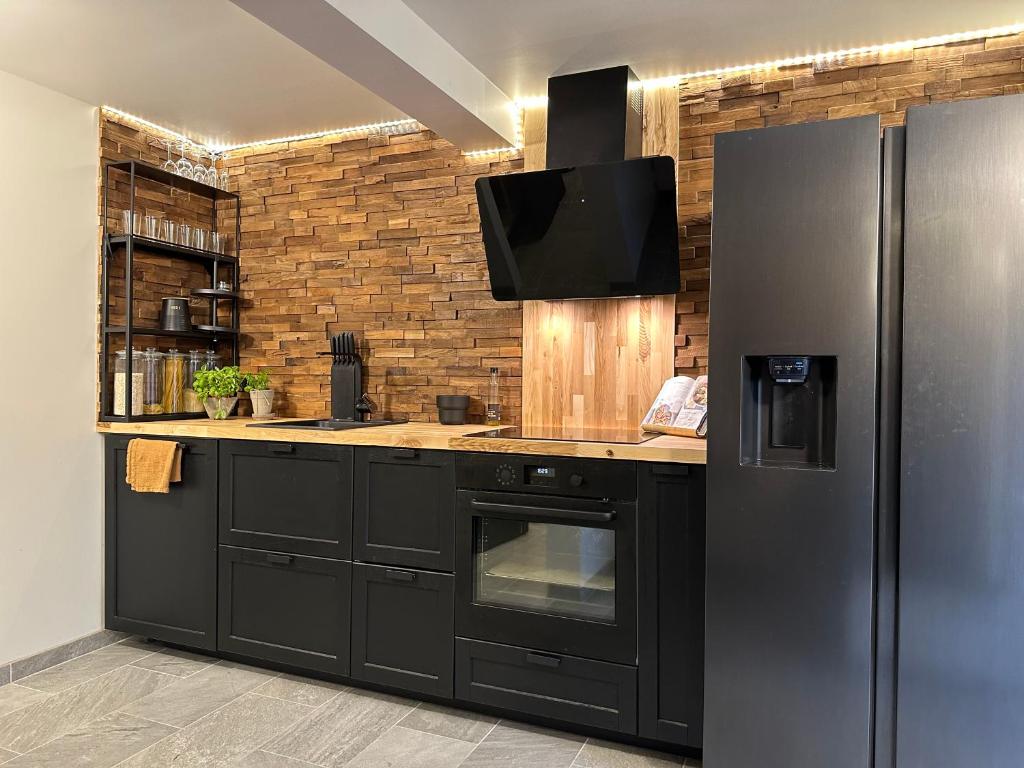 斯塔万格A Place To Stay Stavanger, apartment 1的一间带黑色冰箱的厨房和一台电视