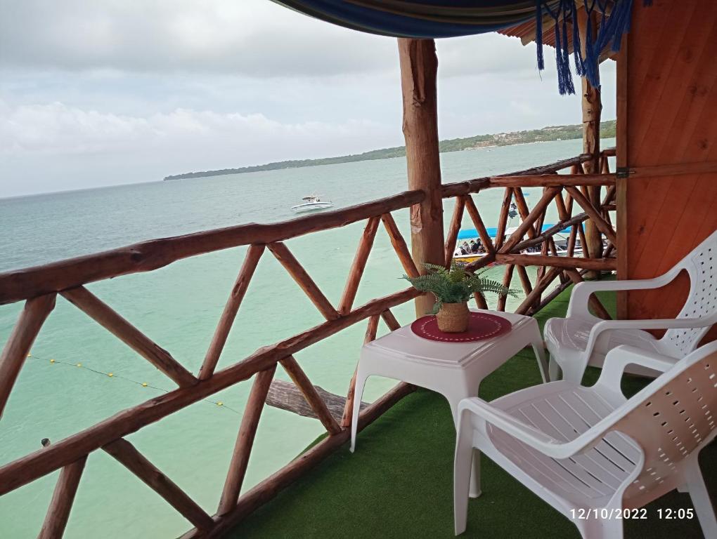 布兰卡滩Posada chikiluky beach的一个带椅子和桌子的门廊和大海