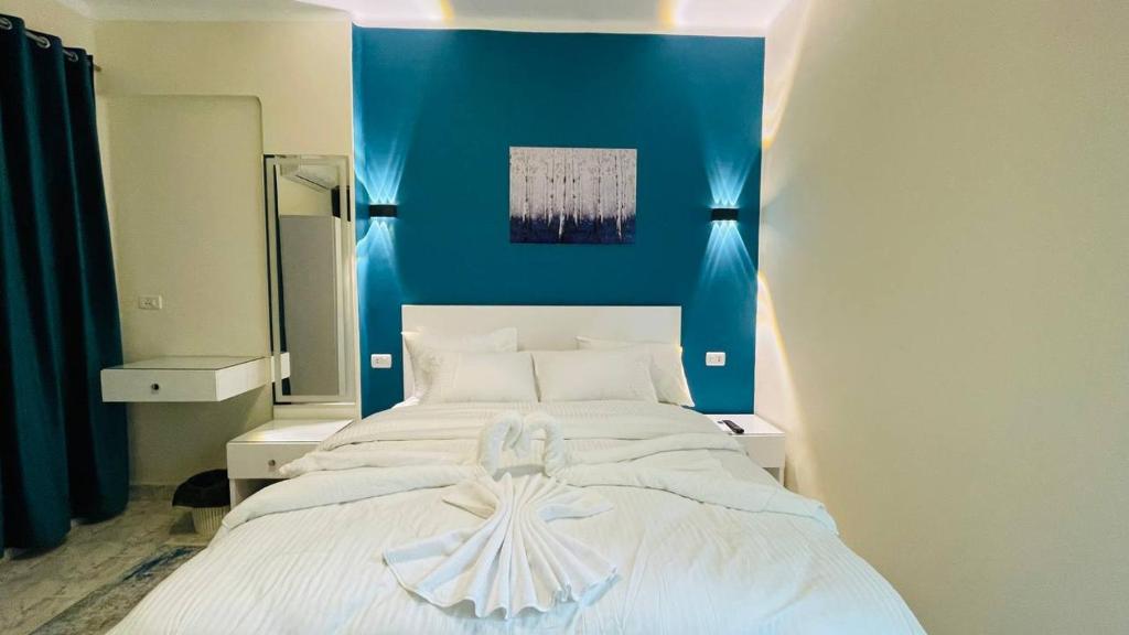 开罗Cozy apartment in down town的一间卧室配有一张白色大床和蓝色的墙壁