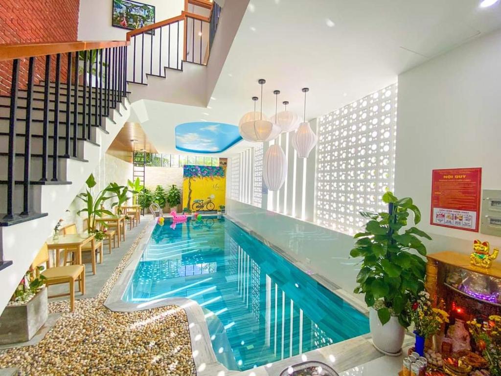 会安Mint Hoi An Villa的一座带楼梯的房屋内的大型游泳池