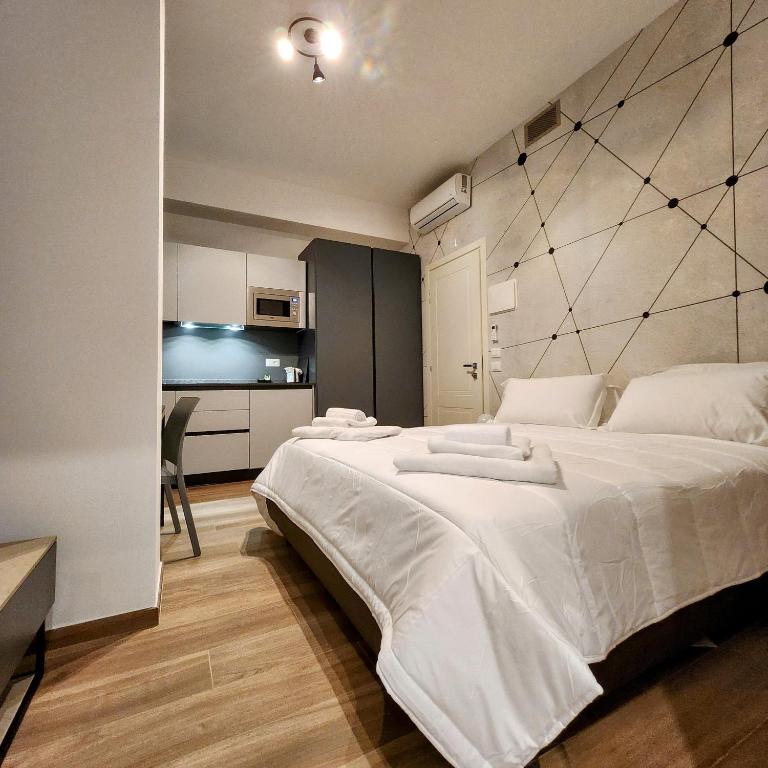 博洛尼亚b&b marconi 49的一间带白色大床的卧室和一间厨房