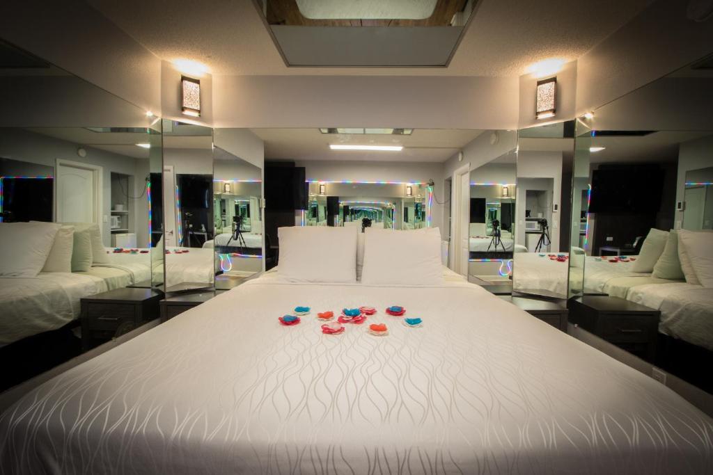 亨德森Envi Boutique Hotel的一张白色大床,上面有眼镜