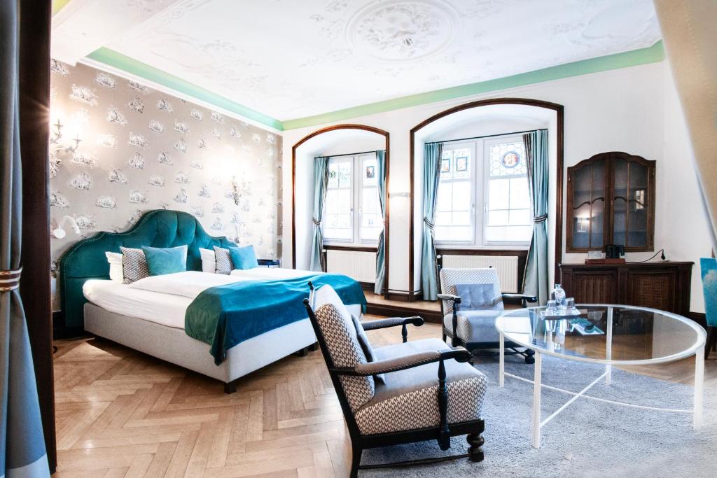 康斯坦茨Romantik Hotel Barbarossa的一间卧室配有一张床和一张玻璃桌