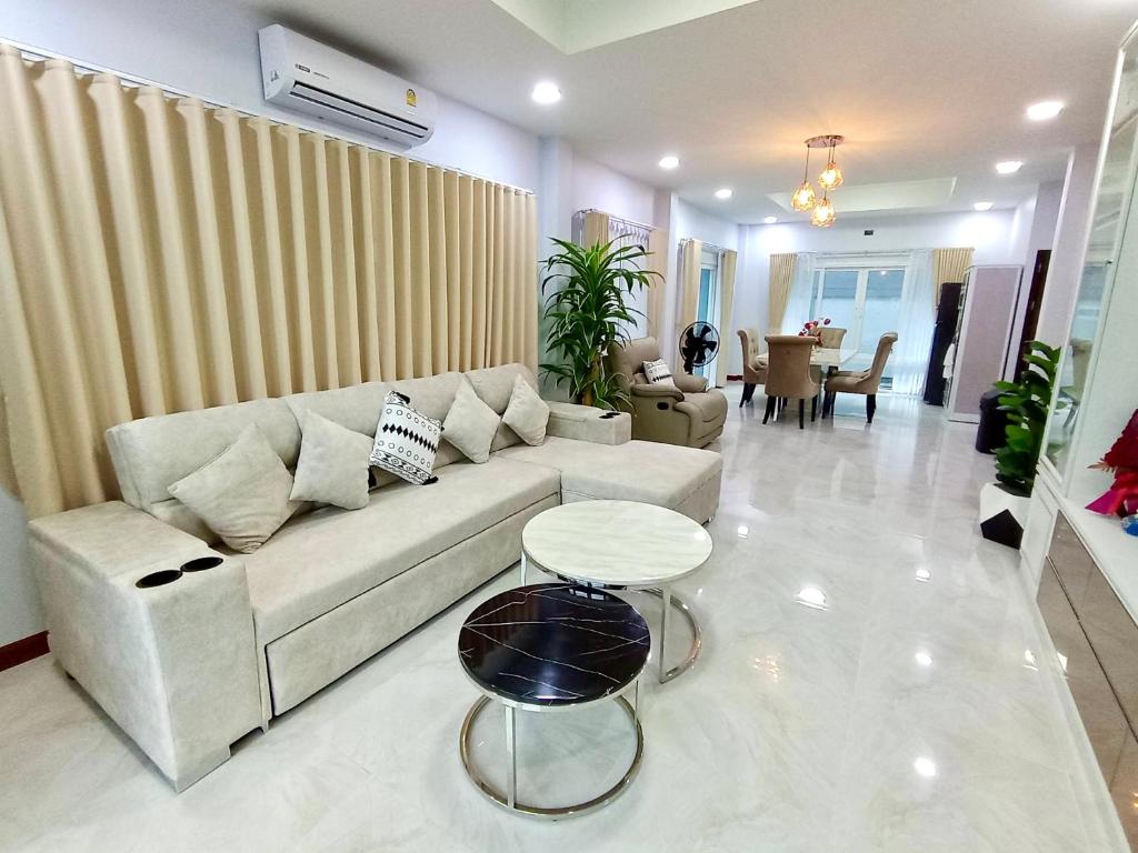 Ban Khlong WaPause Homestay的客厅配有沙发和桌子