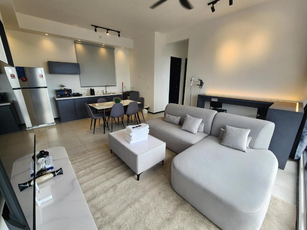 日落洞Executive Urban Suites - George Town @ Penang的一间带白色沙发的客厅和一间厨房