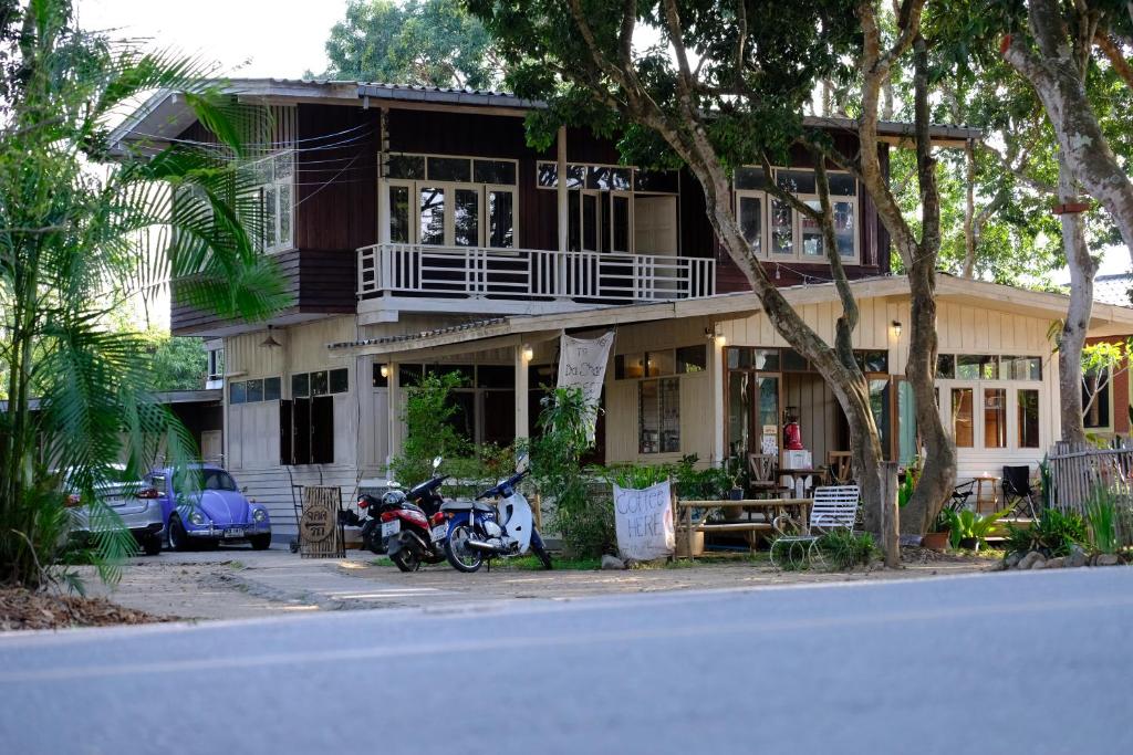 Kampong HuaibūYor Song Hostel Pai的前面有一辆摩托车停放的房子