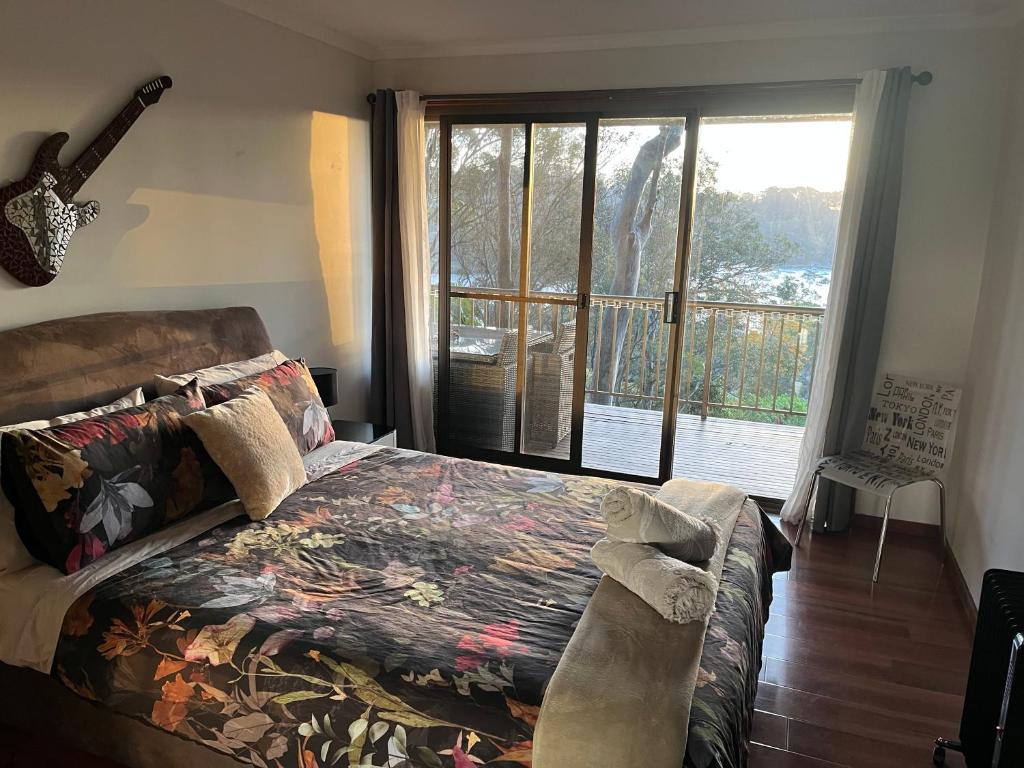 棕榈滩Palm beach Sydney, Modern home with water view的一间带床和大窗户的卧室