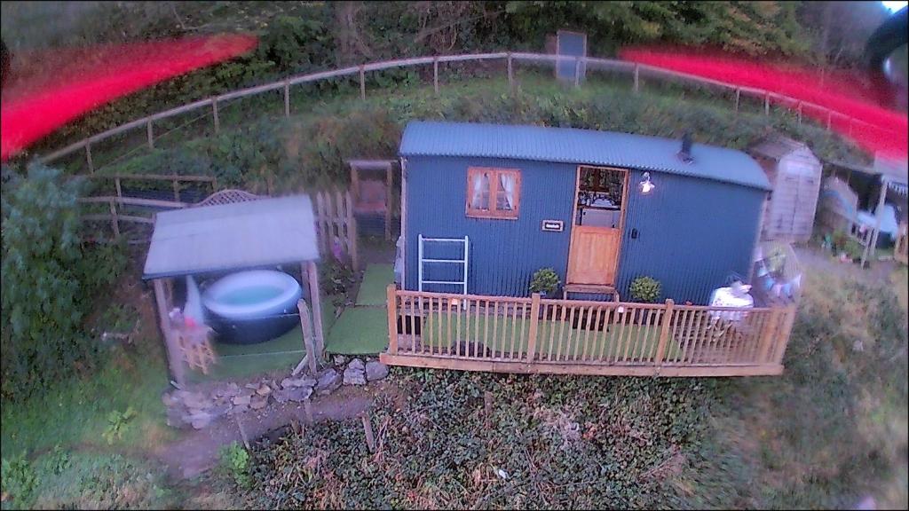 兰戈伦Llangollen Shepherds Huts的享有蓝色小房子的空中景色,设有门廊