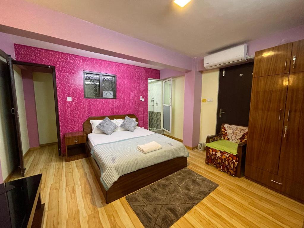 帕坦Kaji Homestay的一间卧室配有一张床和粉红色的墙壁