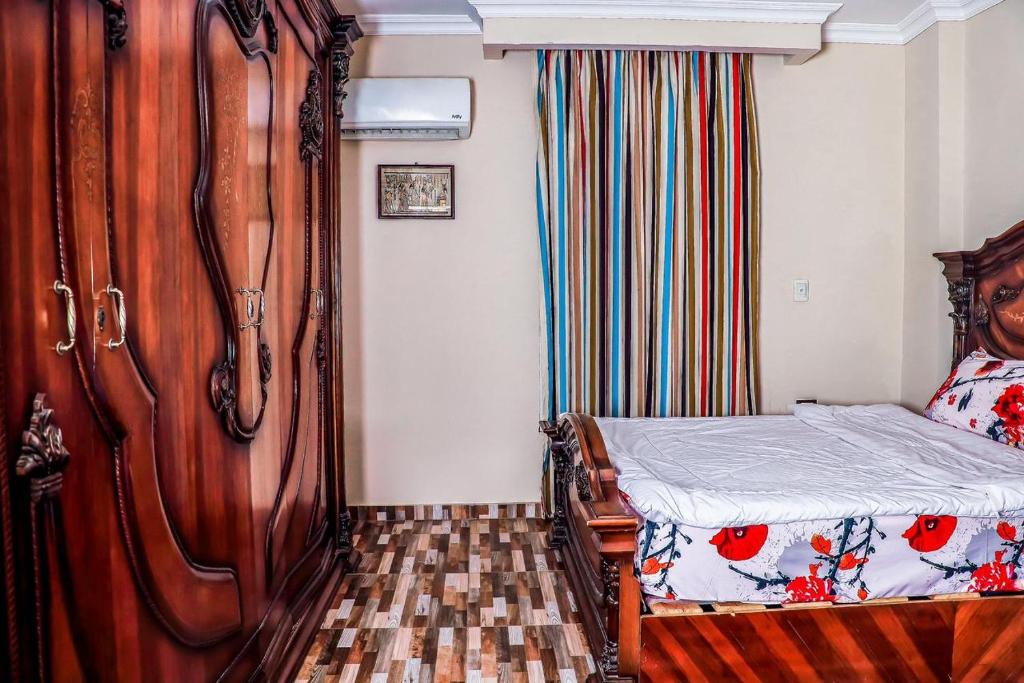 开罗LOVELY PYRAMIDS motel的一间卧室配有一张床和一个木制梳妆台