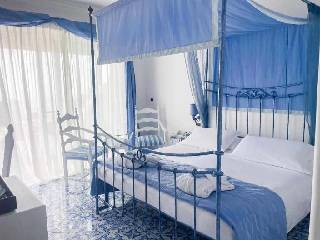 卡普里里贾纳克里斯蒂娜酒店的一间卧室设有两张双层床和蓝色窗帘