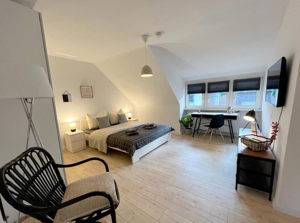 门兴格拉德巴赫Komfortable und gemütliche Wohnung mit 2 SZ的一间卧室配有一张床、一张桌子和一把椅子